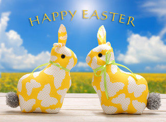 Two Easter yellow bunnies with happy easter text. Easter holiday concept.