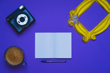 Purple background yellow frame notebook pen coffee mug globe flower flat lay instant photography camera keyboard computer 