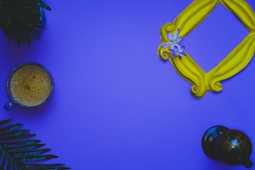 Purple background yellow frame notebook pen coffee mug globe flower flat lay instant photography camera keyboard computer 