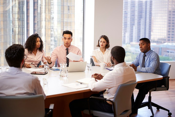 Group Of Business Professionals Meeting Around Table In Modern Office