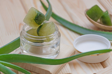 Aloe vera. Natural ingredients for skin or hair care on light wooden background