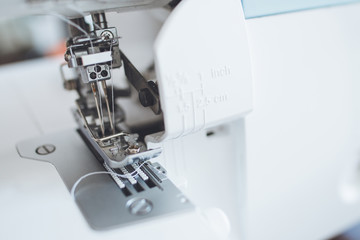 A serger presser foot and some white thread