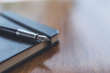 A fountain pen on top of a notebook - Powered by Adobe
