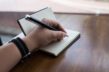 A person taking notes in a notebook with a fountain pen
