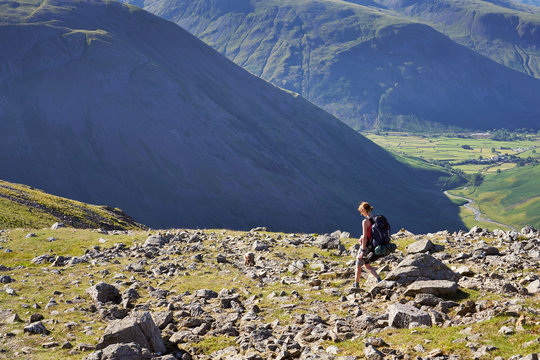 A female hiker backpacking In the English Lake District with views of Kirk Fell and Mosedale.