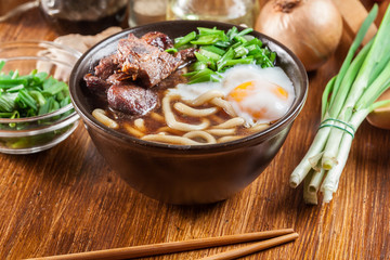 Japanese Udon noodles with beef, egg, green onion and soup - 251571572