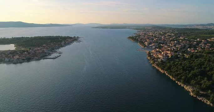 Aerial, top down, drone shot, over light green finnish woods and scandinavian, green gold trees, on a sunny, summer evening, in Finland, Scandinavia