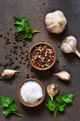 Black, red and white peppersalt, salt, garlic in a wooden bowl . Classic spices for cooking. View from above.