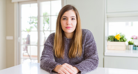 Naklejka premium Beautiful young woman at home with serious expression on face. Simple and natural looking at the camera.