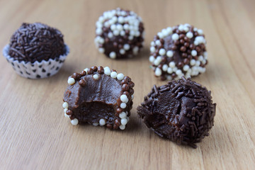 brigadeiro (brigadier), sweet chocolate typical of Brazilian cuisine covered with particles, in a wooden background.