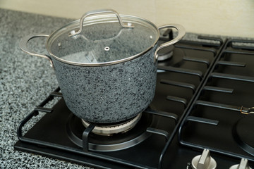 A medium-sized pan on a black gas stove