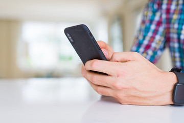 Close up of man hands using smartphone and smiling