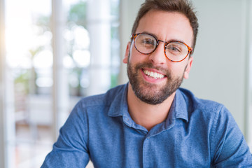 Obraz premium Handsome man wearing glasses and smiling relaxed at camera