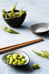 Edamame Bohnen gekocht, gepult und mit Meersalz gesalzen in kleiner Schüssel appetitlich angerichtet und von vorne fotografiert