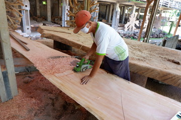 people's activities are smoothing wood with a machine