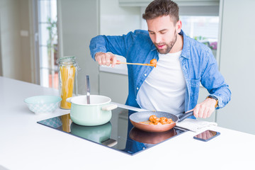 Handsome man cooking pasta at home