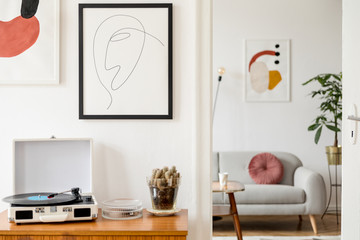 Vintage and retro interior of living room with design commode, vinyl recorder, cacti and mock up...
