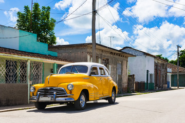 Amerikanischer gelber Oldtimer mit weissem Dach parkt in der Seitenstrasse in Havanna City Cuba - Serie Kuba Reportage