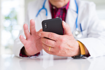 Close up of doctor man hands using smartphone and wearing stethoscope