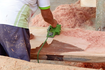 people's activities are smoothing wood with a machine