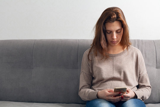  Young woman and mobile phone in a room.