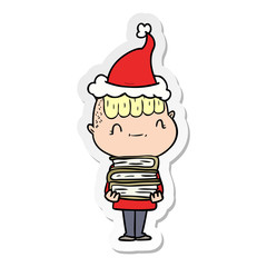 sticker cartoon of a friendly boy with books wearing santa hat