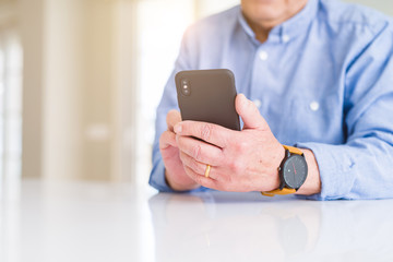 Close up of man hands using smartphone over white table