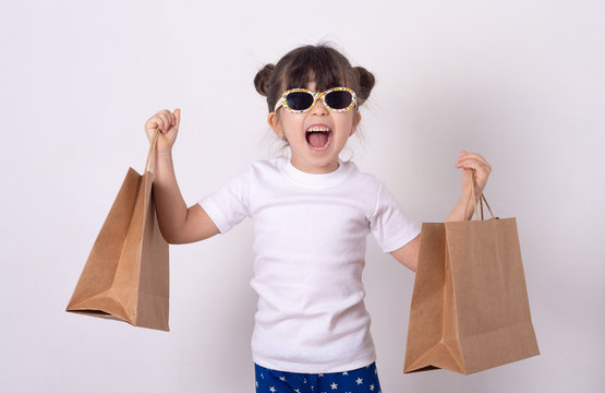 Smiling kid buy purchases. Little girl wearing sunglasses on shopping. 