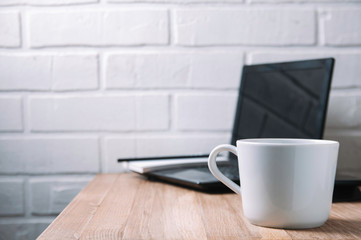 White mug on wooden desktop. Template for text or design. Home office concept