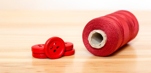 Diy concept - red sewing supplies - web banner of button and thread