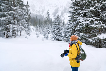The photographer in winter forest in mountains