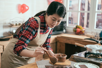 Steps of making chocolate cake filling silicone mold with pastry. young woman in apron prepare handmade dessert for valentine day gift for boyfriend. lady in pinafore cooking in wooden kitchen.