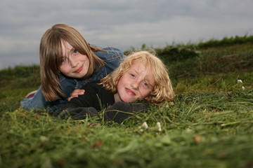 Two girls lying on the meadow.