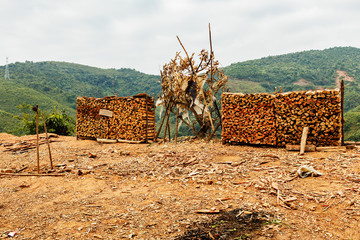 stacked firewood for sale in the mountains near the road, Laos