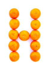 Letter solved with tangerines isolated on white background. Mandarine «H» letter