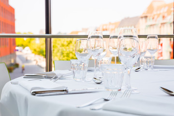Empty glasses on a table covered with a white tablecloth in front of the panoramic window