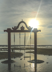 Arch with swings next to the sea, lagoon, lake