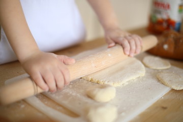 in the kitchen the baby rolls and plays with the dough and make pizza and bread