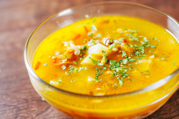 chicken soup with vegetables and rice in glass Bowl on wooden table background