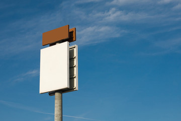 Empty copy space blank white bilboard with blue cloudy sky in the background.