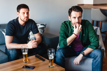 Two guys watching football match on TV