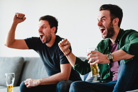 Two Guys Watching Football Match On TV