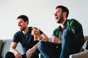 Two guys watching football match on TV