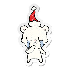 crying polar bear distressed sticker cartoon of a wearing santa hat