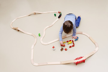 Ein kleiner Junge spielt mit einer Holzeisenbahn