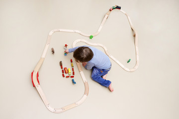 Ein kleiner Junge spielt mit einer Holzeisenbahn