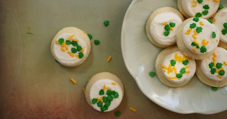 St Patricks day frosted cookies with green clover leaf sprinkles, selective focus