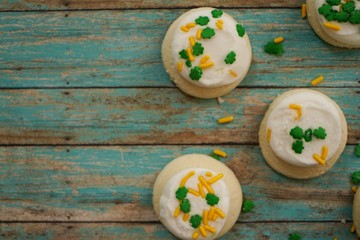 St Patricks day frosted cookies with green clover leaf sprinkles, selective focus