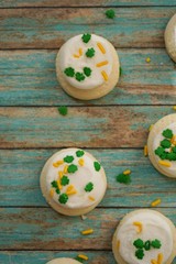 St Patricks day frosted cookies with green clover leaf sprinkles, selective focus