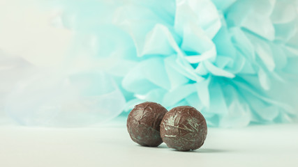 Round chocolates on a gentle blue background. Copy space. Selective focus.